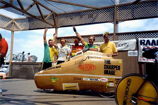 Michael Shermer (second from the right) with his teammates in the 4-man relay team that rode this fully faired recumbent bicycle across America in 1989. Although much faster than a normal upright bicycle on the flats and downhills, recumbents are slower on climbs and do not turn or maneuver as well in turns and traffic.