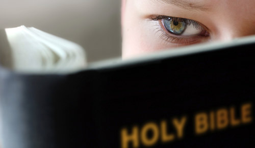 a boy reading the Holy Bible