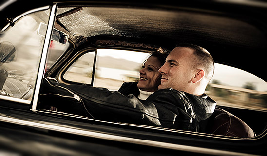 man and woman riding in vintage car